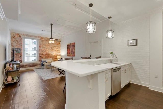 kitchen with brick wall, sink, hanging light fixtures, dark hardwood / wood-style flooring, and white cabinetry