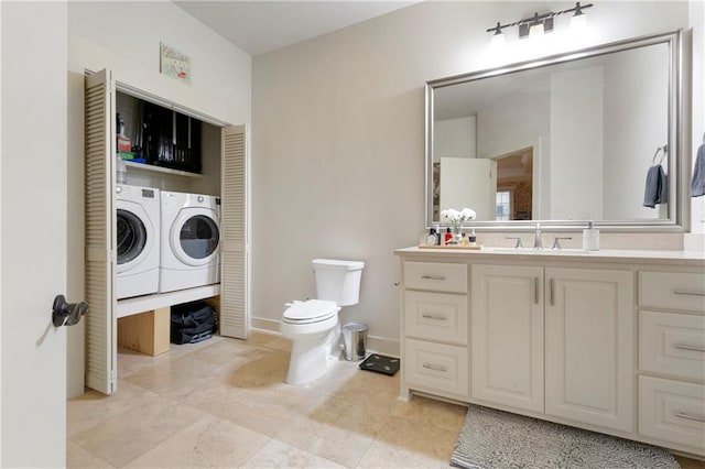 bathroom featuring vanity, washing machine and dryer, tile flooring, and toilet