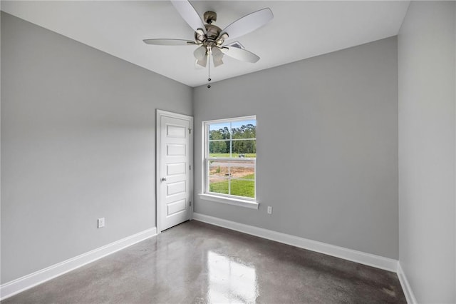 spare room with ceiling fan and concrete floors