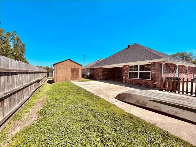 view of yard featuring a shed, a wooden deck, and a patio area