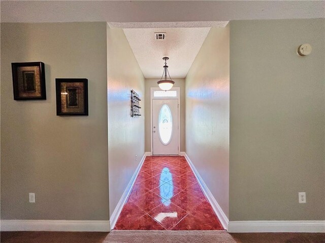 doorway featuring tile patterned floors and a textured ceiling