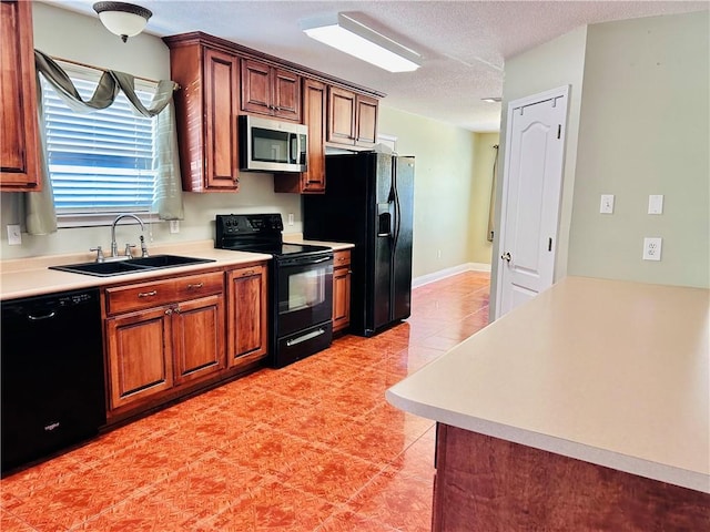 kitchen with sink, light tile patterned floors, black appliances, and a textured ceiling