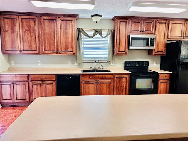 kitchen with sink, a textured ceiling, and black appliances