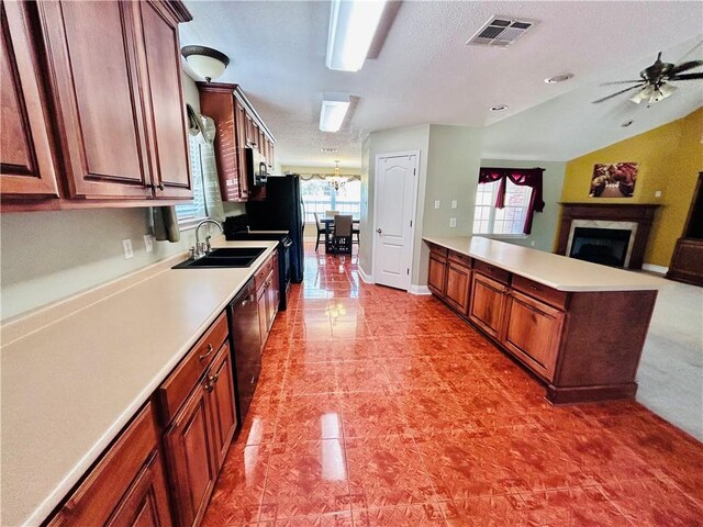 kitchen with sink, ceiling fan with notable chandelier, vaulted ceiling, and black appliances