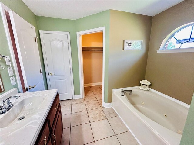 bathroom with tile patterned floors, a bathtub, and vanity