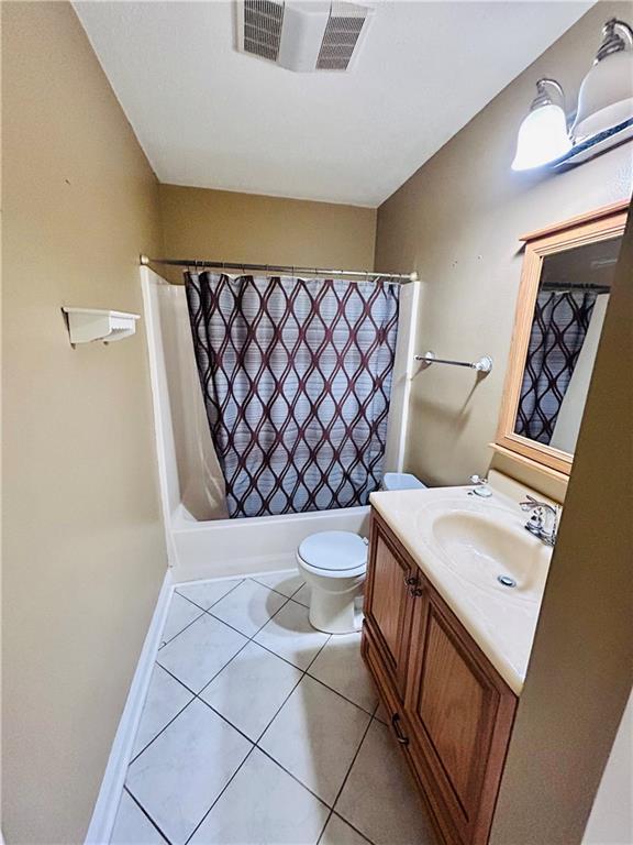 full bathroom featuring tile patterned flooring, vanity, shower / tub combo, and toilet