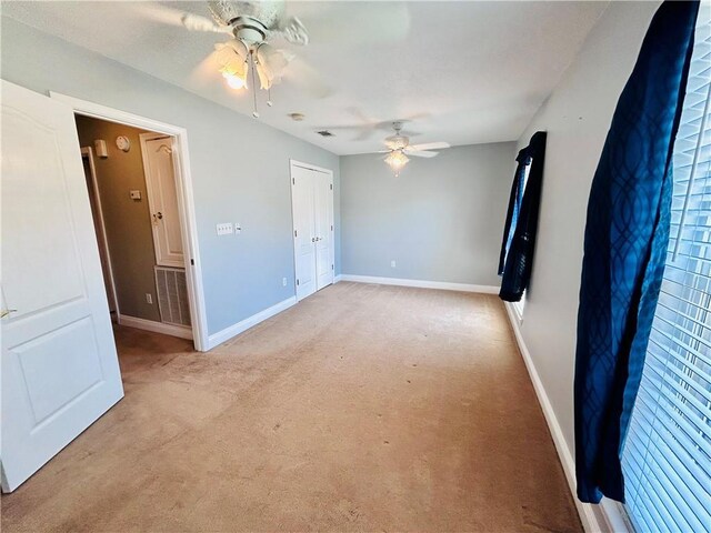 empty room with light colored carpet and ceiling fan