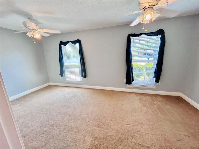 empty room featuring light carpet, a textured ceiling, and ceiling fan