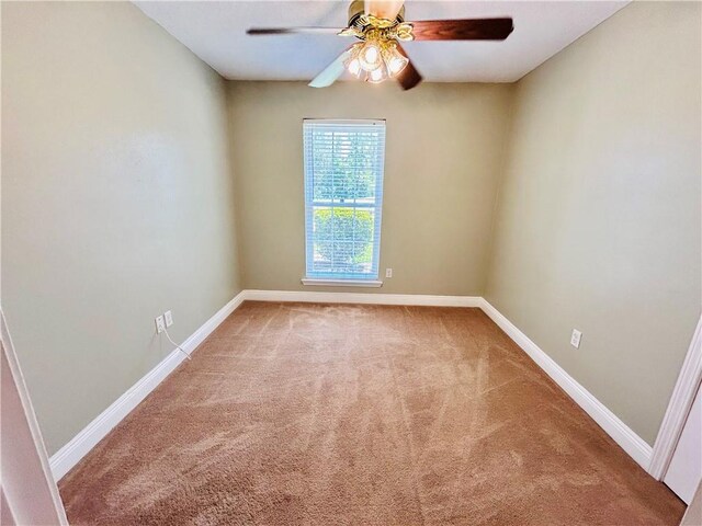 spare room with ceiling fan and carpet