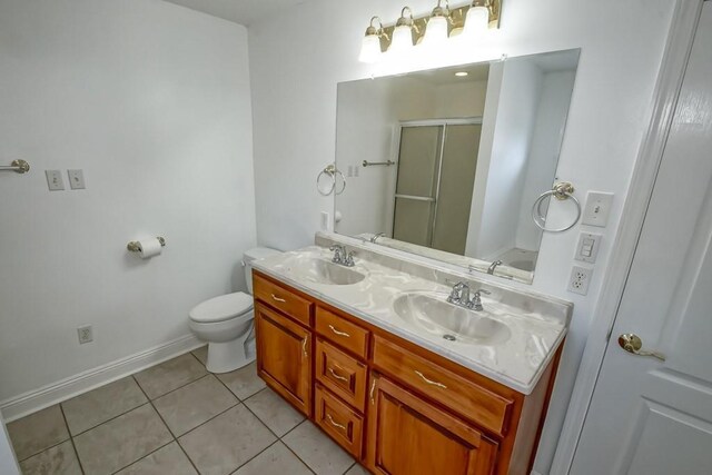 bathroom featuring an enclosed shower, vanity, tile patterned floors, and toilet