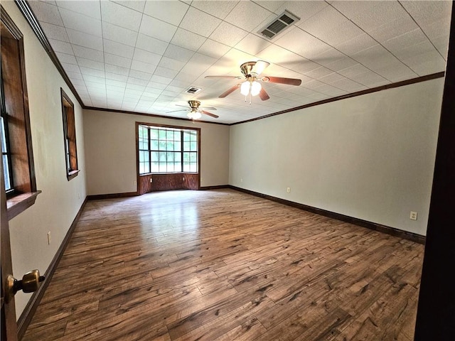 empty room featuring ceiling fan, dark wood-type flooring, and ornamental molding