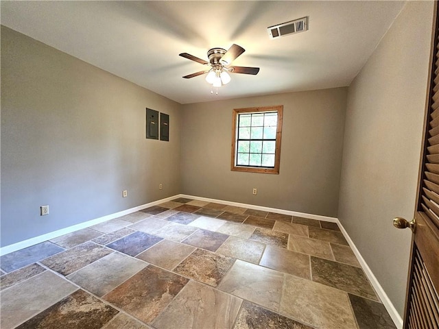 spare room featuring ceiling fan and dark tile flooring