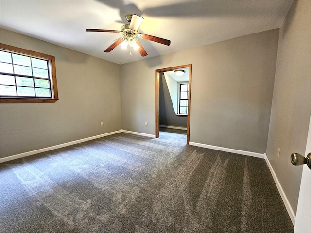 empty room with dark carpet and ceiling fan