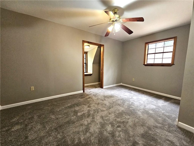 carpeted spare room featuring ceiling fan