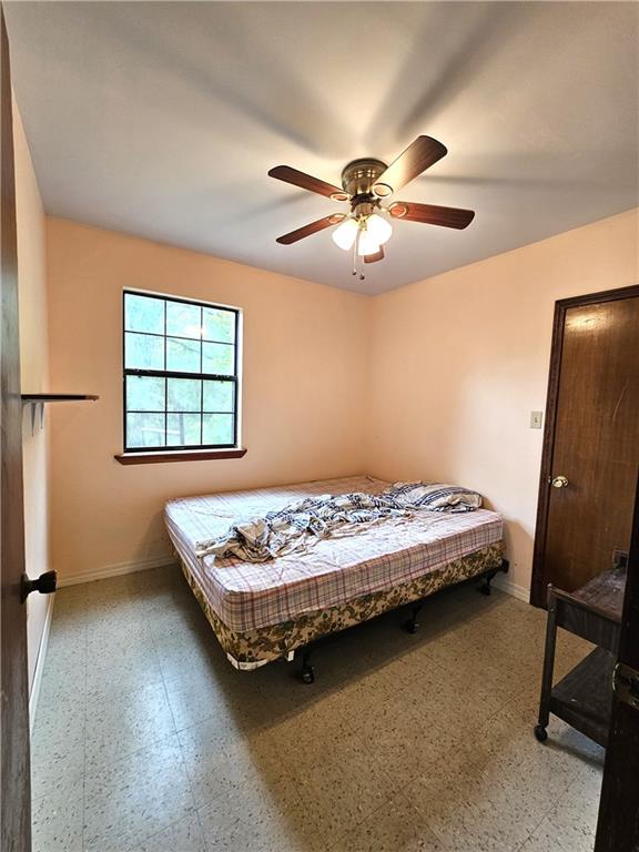 tiled bedroom featuring ceiling fan