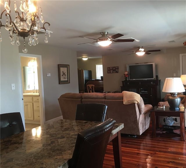 living room with dark wood-type flooring, sink, and ceiling fan with notable chandelier