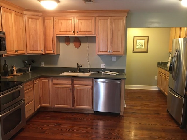 kitchen featuring appliances with stainless steel finishes, dark hardwood / wood-style floors, and sink