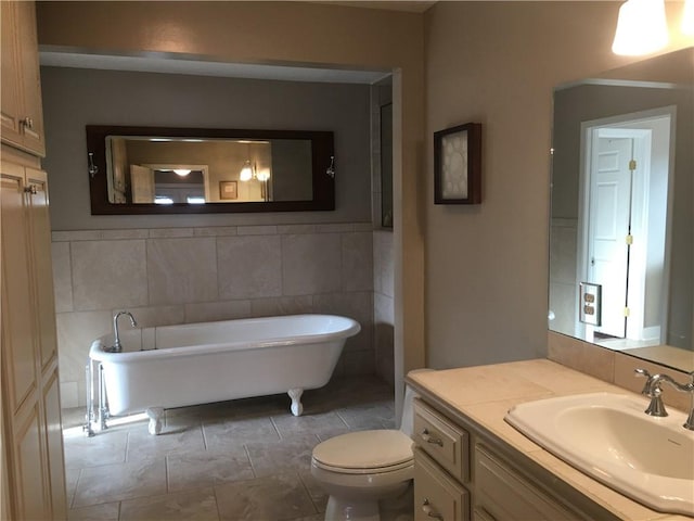 bathroom featuring tile walls, toilet, tile flooring, a tub, and vanity