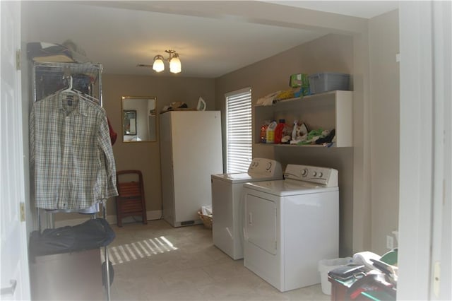 laundry area with light tile floors and washer and clothes dryer