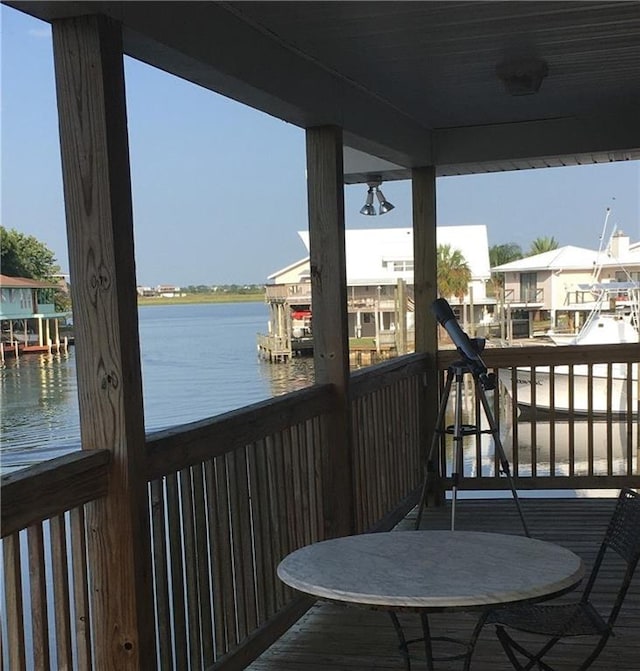 balcony featuring a water view and a boat dock