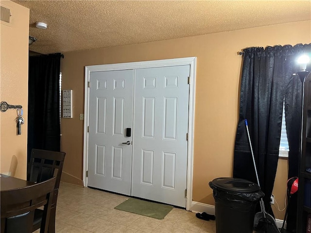 tiled bedroom with a closet and a textured ceiling