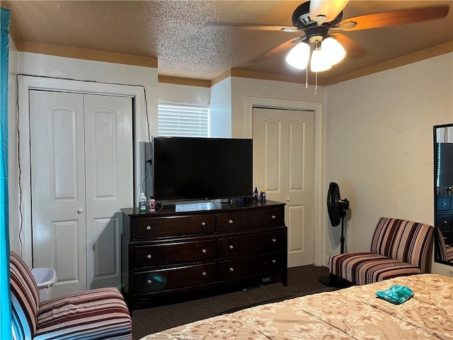 bedroom with ceiling fan, dark carpet, and a textured ceiling