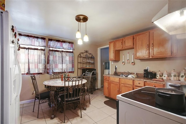 kitchen featuring range, white refrigerator, light tile floors, pendant lighting, and sink