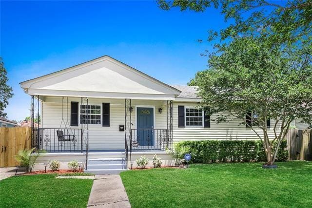 view of front of property featuring covered porch and a front lawn