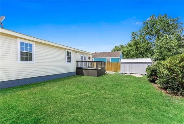 view of yard featuring a deck and a storage shed