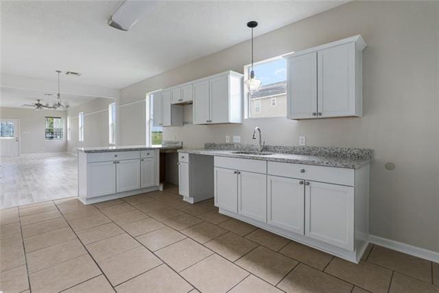 kitchen with light tile floors, white cabinetry, and a wealth of natural light