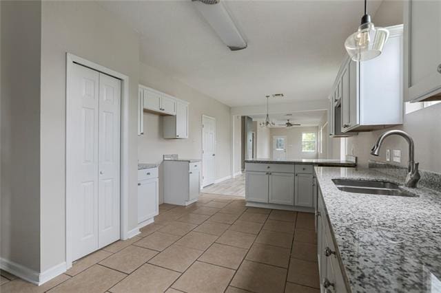 kitchen with hanging light fixtures, sink, and light tile floors