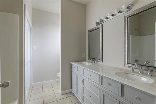 bathroom with dual sinks, tile floors, toilet, and oversized vanity