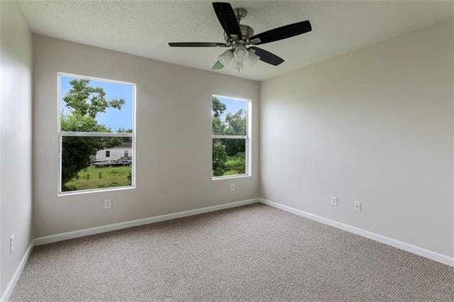 spare room featuring ceiling fan and light colored carpet