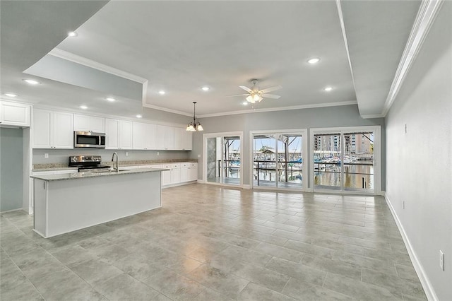 kitchen featuring white cabinets, hanging light fixtures, stainless steel appliances, and ceiling fan with notable chandelier