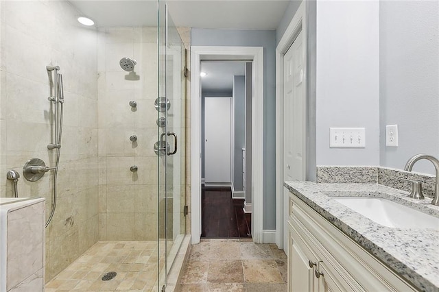 bathroom with tile floors, vanity, and a shower with shower door