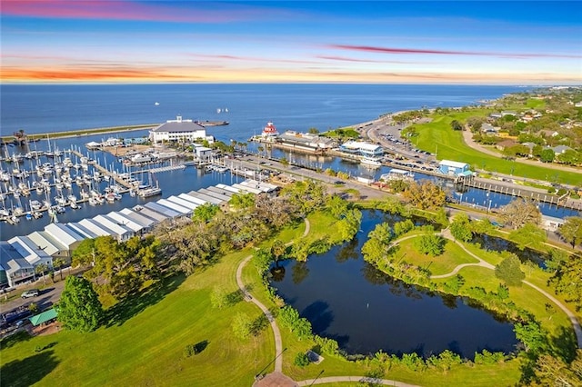 aerial view at dusk featuring a water view