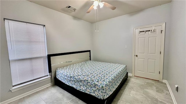 bedroom with ceiling fan and light tile floors