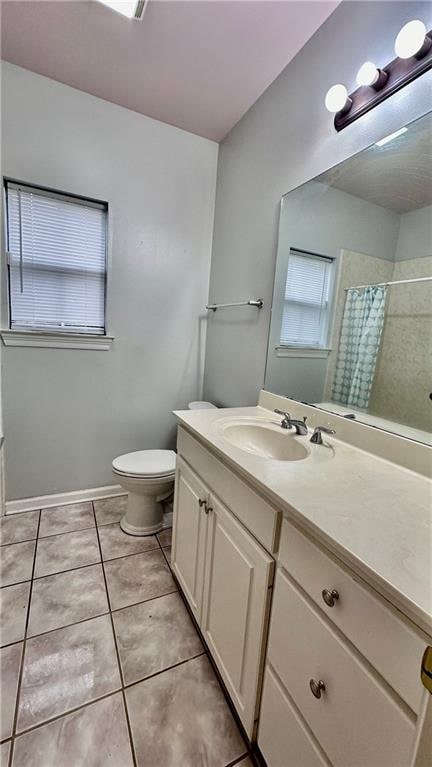 bathroom featuring vanity, tile flooring, and toilet