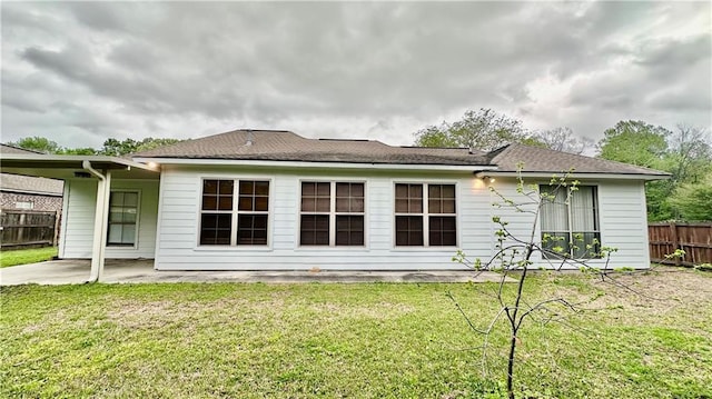 rear view of property featuring a lawn and a patio