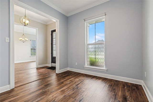 empty room with crown molding, plenty of natural light, dark wood-type flooring, and an inviting chandelier