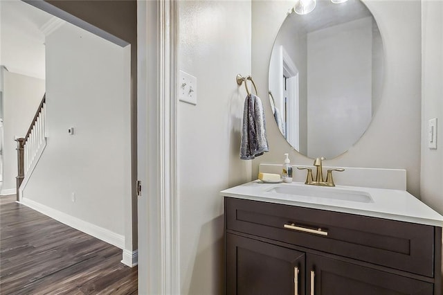 bathroom with hardwood / wood-style floors, vanity, and ornamental molding