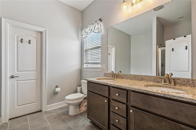 bathroom with tile patterned flooring, vanity, toilet, and a shower with shower door