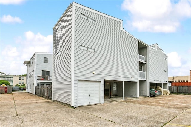 exterior space with cooling unit, a garage, and a carport