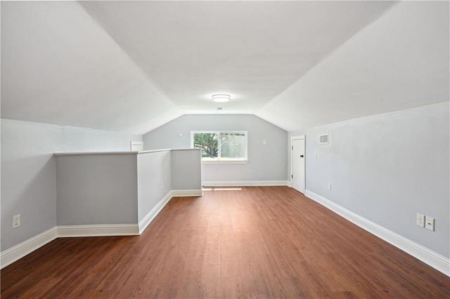 additional living space featuring hardwood / wood-style flooring and vaulted ceiling