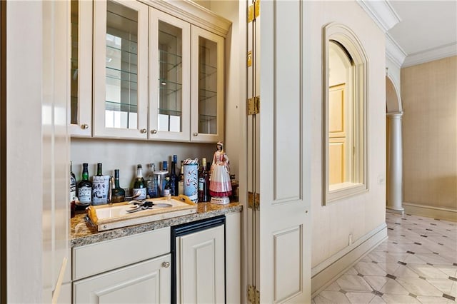 bar featuring crown molding, light stone countertops, and white cabinets