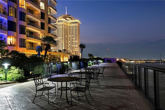 patio terrace at dusk featuring a balcony