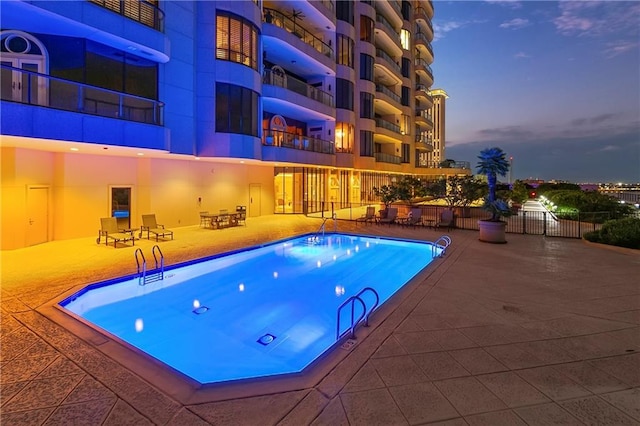 pool at dusk with a patio