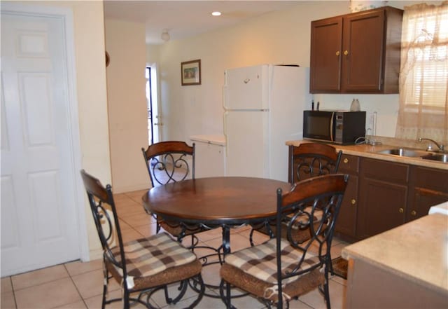 tiled dining room featuring sink