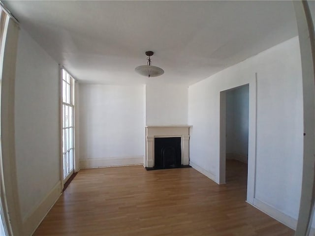 1322 Kerlerec St, New Orleans, LA 70116 - unfurnished living room featuring wood finished floors, a fireplace, and baseboards