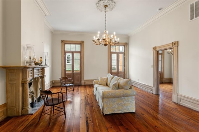 living room featuring a wealth of natural light, crown molding, dark hardwood / wood-style flooring, and an inviting chandelier